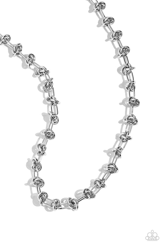 Paparazzi Accessories Knotted Kickoff - Silver Featuring a silver paperclip link chain, a series of sleek silver knots coalesces around the collar for an industrially edgy statement. Features an adjustable clasp closure. Sold as one individual necklace. I