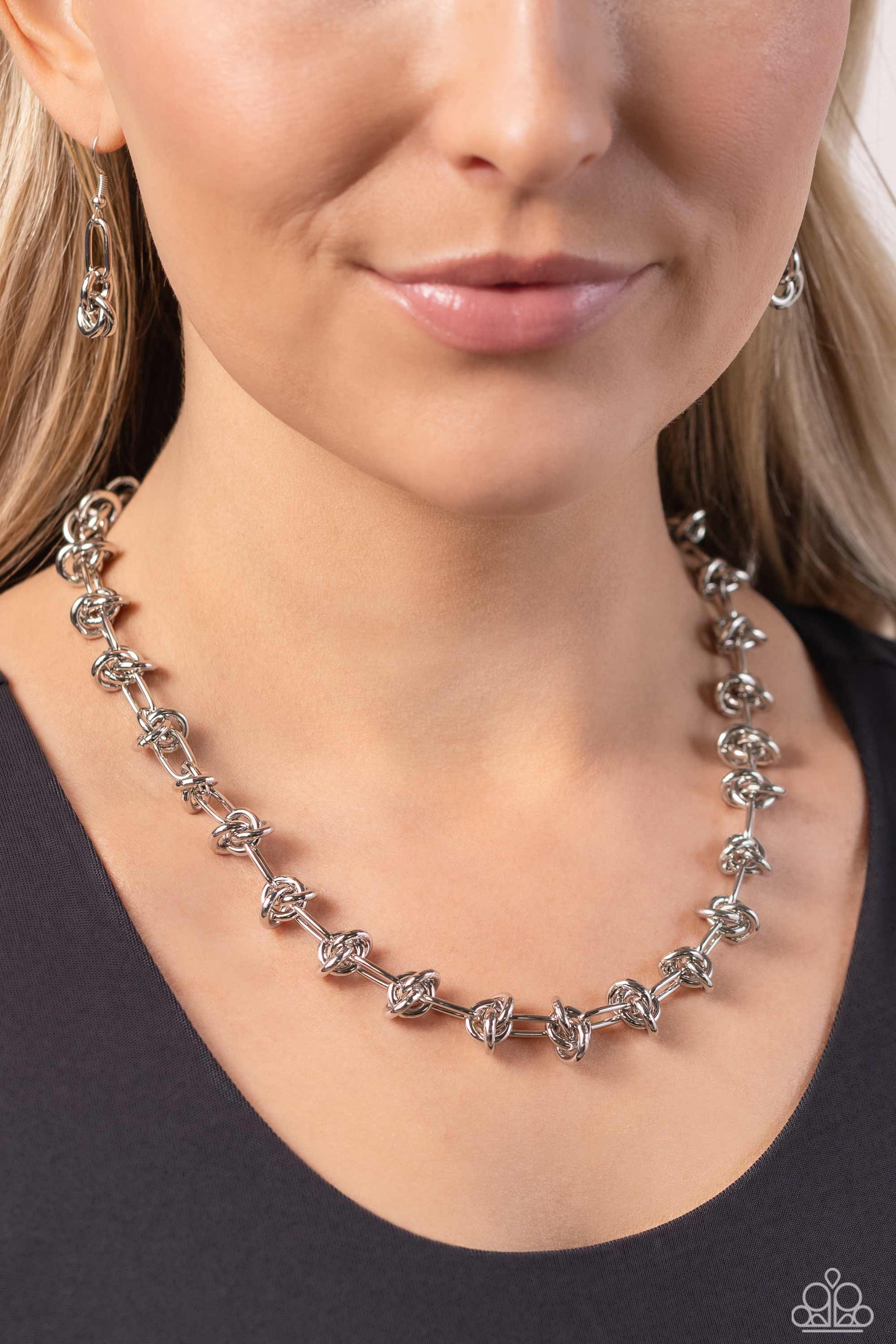 Paparazzi Accessories Knotted Kickoff - Silver Featuring a silver paperclip link chain, a series of sleek silver knots coalesces around the collar for an industrially edgy statement. Features an adjustable clasp closure. Sold as one individual necklace. I