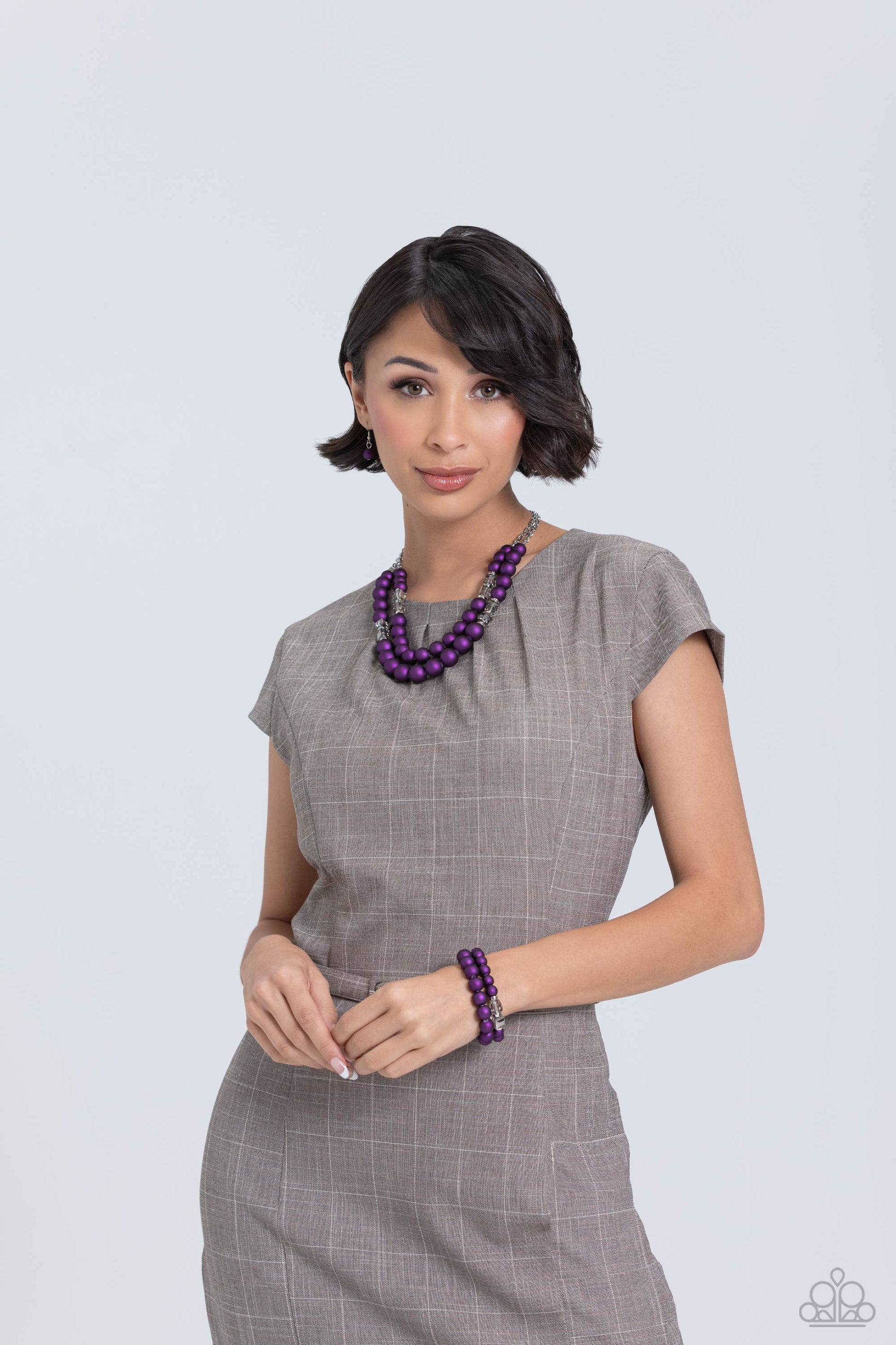 Paparazzi Accessories Shopaholic Showdown - Purple Two strands of oversized purple beads featuring a subtle shimmer, silver accents, and clear gray cubed beads stretch around the wrist, creating refined, colorful layers. Sold as one set of two bracelets.