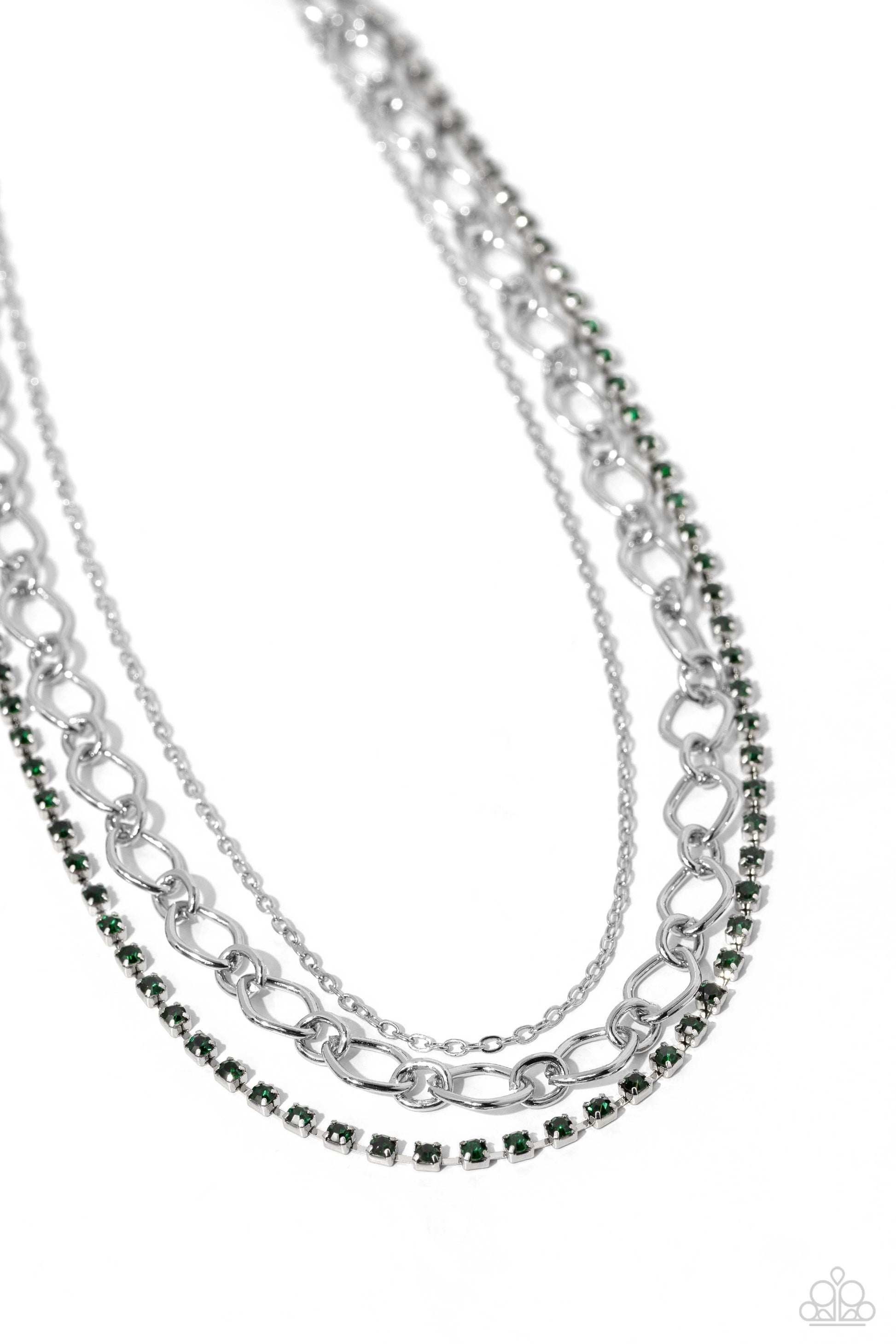 Paparazzi Accessories Tasteful Tiers - Green A dainty strand of emerald green rhinestones, set in silver square fittings, joins a dainty silver strand of silver chain and a silver oval link chain below the collar, creating refined layers. Features an adju