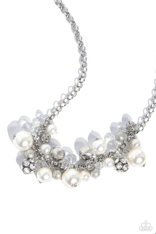 Paparazzi Accessories Corporate Catwalk - White A collection of bubbly white pearls, glittery crystal-like beads, silver beads, some embossed in shimmer, and gem-encrusted beads swing from the bottom of a chunky silver chain, creating an elegantly cluster