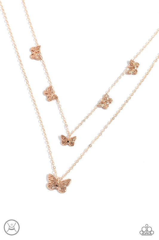 Paparazzi Accessories Butterfly Beacon - Rose Gold Floating along a dainty rose gold chain, a collection of ornate rose gold butterflies coalesces down the neckline for a whimsical finish. A larger rose gold butterfly, featuring the same ornate detail swi
