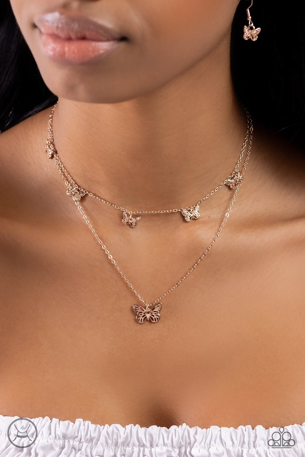 Paparazzi Accessories Butterfly Beacon - Rose Gold Floating along a dainty rose gold chain, a collection of ornate rose gold butterflies coalesces down the neckline for a whimsical finish. A larger rose gold butterfly, featuring the same ornate detail swi