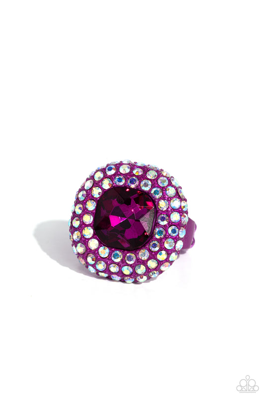 Paparazzi Accessories Glistening Grit - Pink Featuring a regal square cut, an oversized fuchsia gem nestles inside a rounded square pink metallic frame encrusted in glassy iridescent rhinestones for a dramatically glamorous look. Features a dainty stretch
