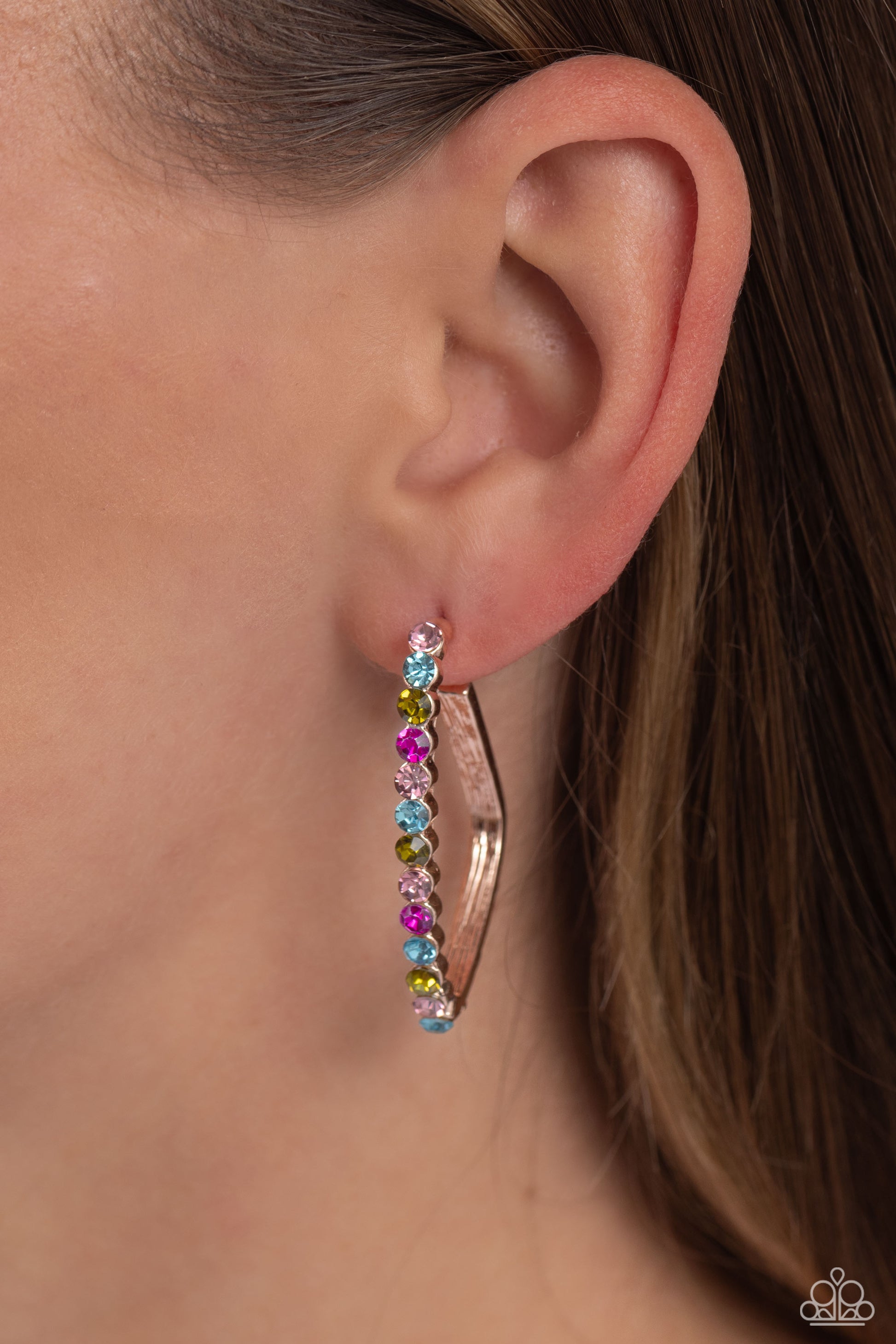 Paparazzi Accessories Triangular Tapestry - Rose Gold The front of a bold rose gold hoop is encrusted in multicolored rhinestones, creating a sparkly spectrum of color. The multicolored scalloped frame leisurely bends into an airy triangular frame for a g