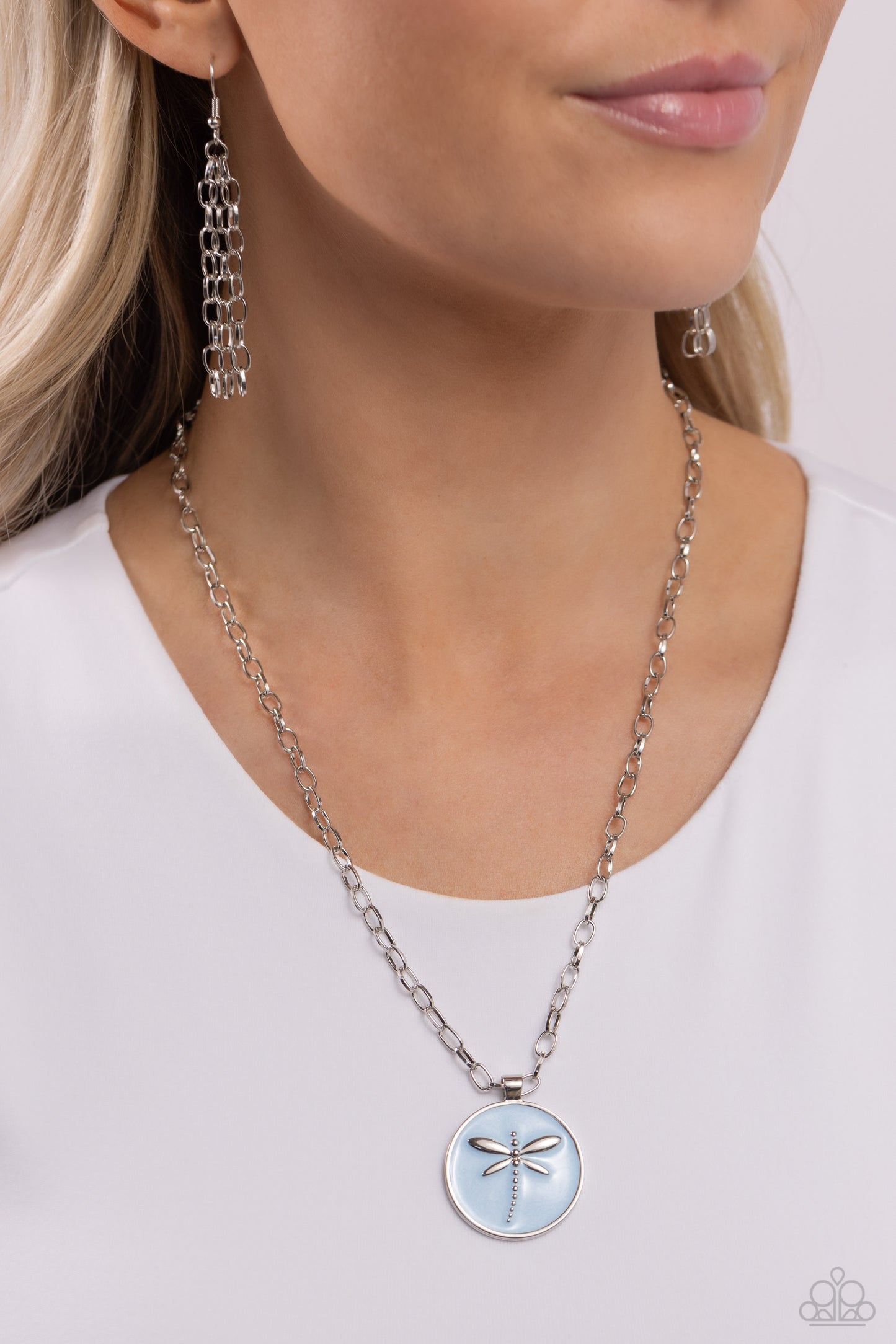 Paparazzi Accessories Decorative Dragonfly - Blue Featuring a light blue pearl paint backdrop, a silver dragonfly dances at the center of a silver pendant adding an elegantly rugged aesthetic to a silver link chain. Features an adjustable clasp closure. S