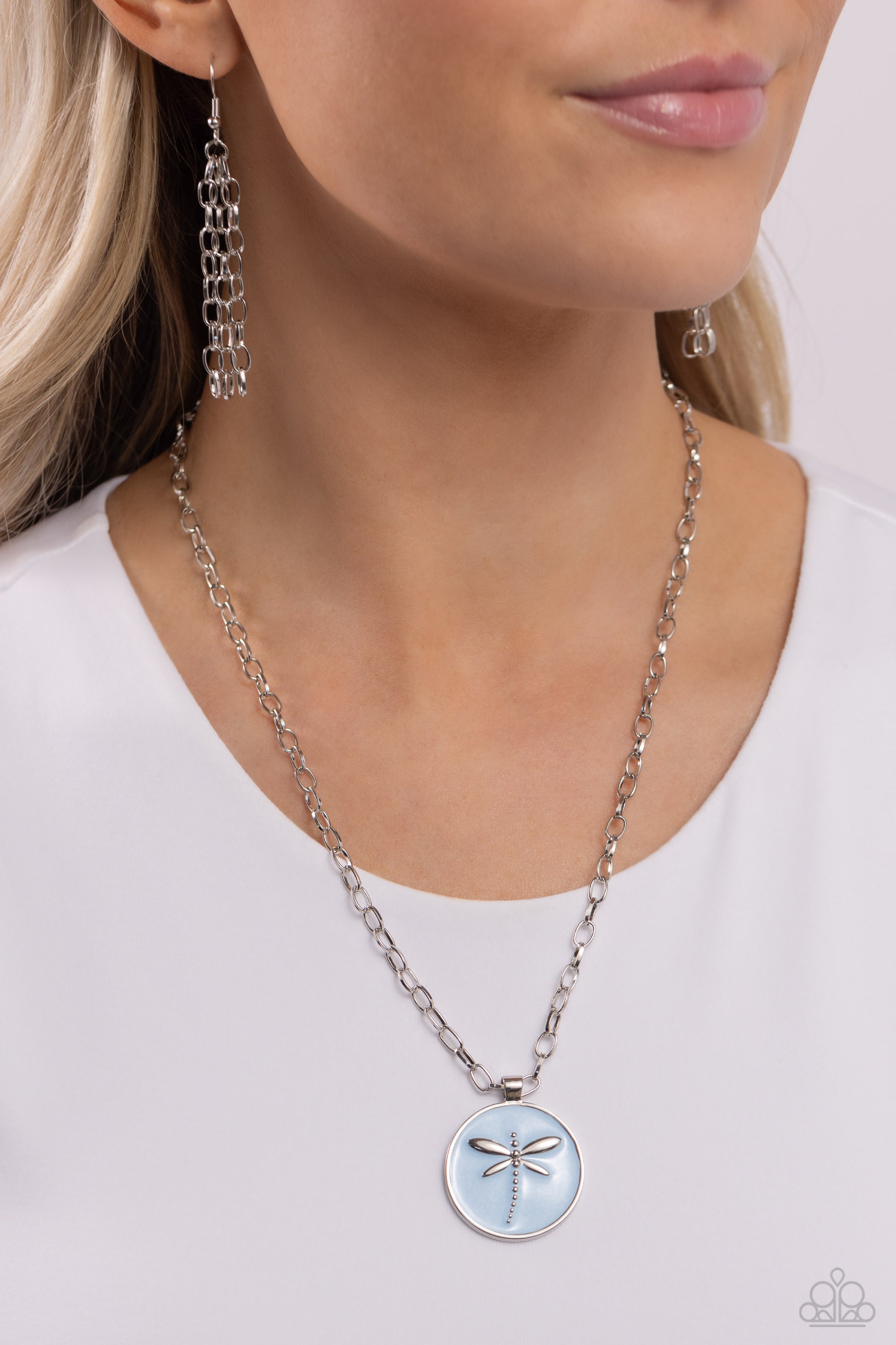 Paparazzi Accessories Decorative Dragonfly - Blue Featuring a light blue pearl paint backdrop, a silver dragonfly dances at the center of a silver pendant adding an elegantly rugged aesthetic to a silver link chain. Features an adjustable clasp closure. S