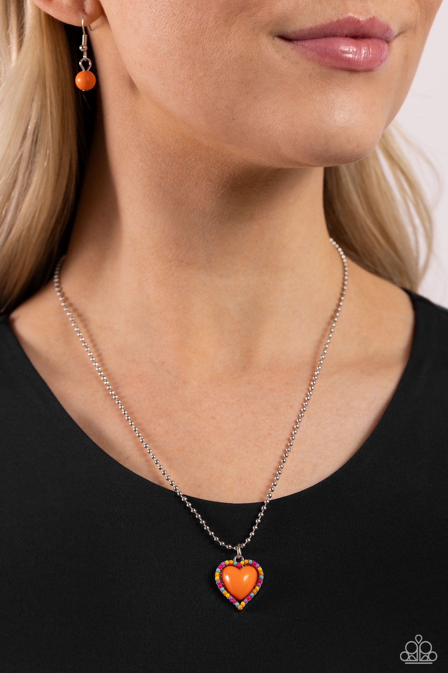 Paparazzi Accessories Romantic Ragtime - Orange Featuring an acrylic orange center, a charming heart pendant, enveloped in dainty Pink Peacock, orange, yellow, tiffany, and lavender acrylic beads, is suspended from a strand of silver ball chain below the