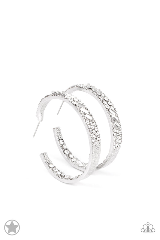 Paparazzi Accessories GLITZY By Association - White The front facing surface of a chunky silver hoop is dipped in brilliantly sparkling rhinestones while light-catching texture wraps around the back. The interior of the hoop features the opposite pattern,