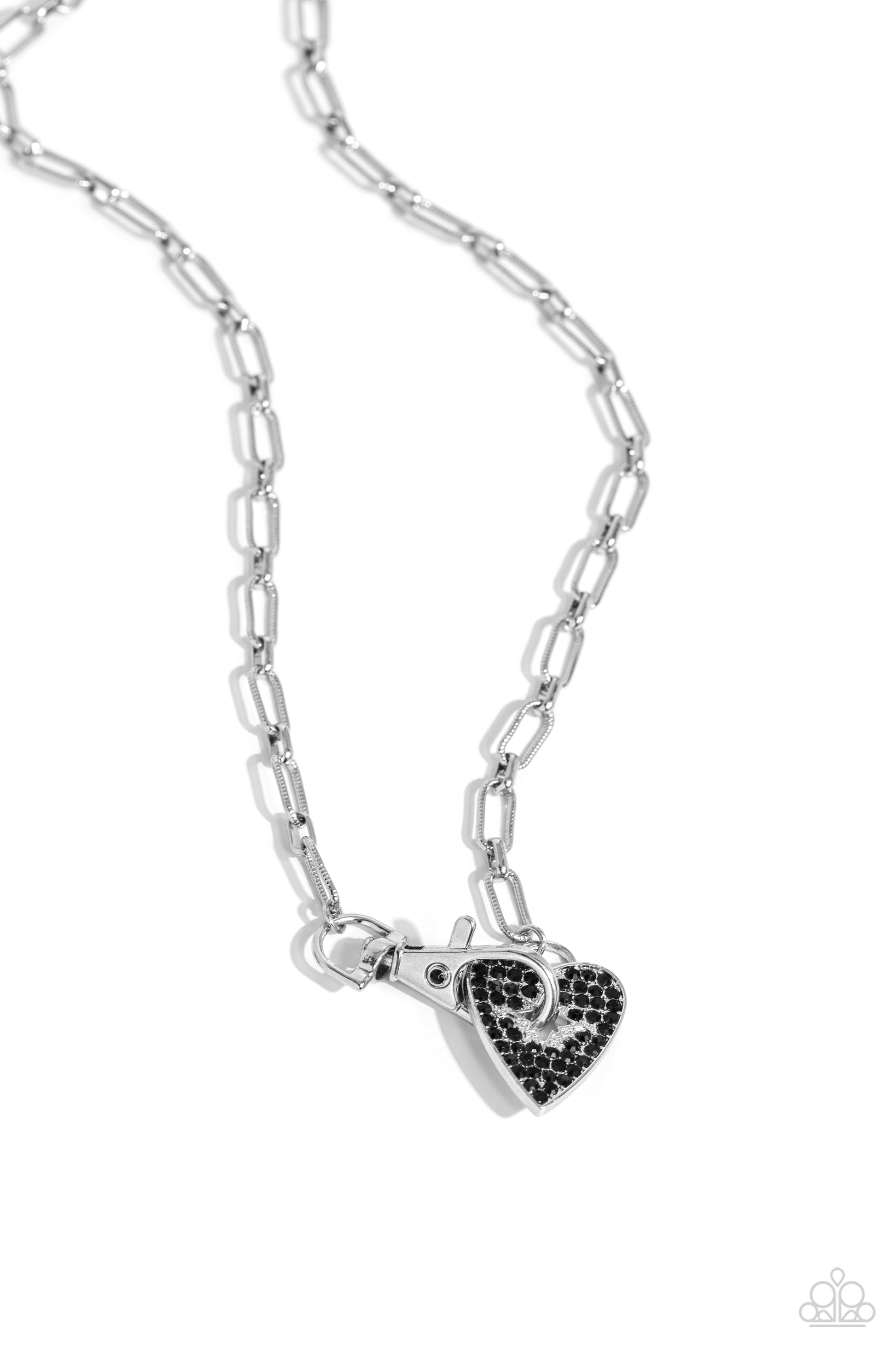 Paparazzi Accessories Radical Romance - Black Featuring a subtly studded finish, a silver paperclip chain leads the eye down to a black rhinestone-encrusted heart. A black rhinestone-embellished lobster clasp connects to the center of the heart display fo