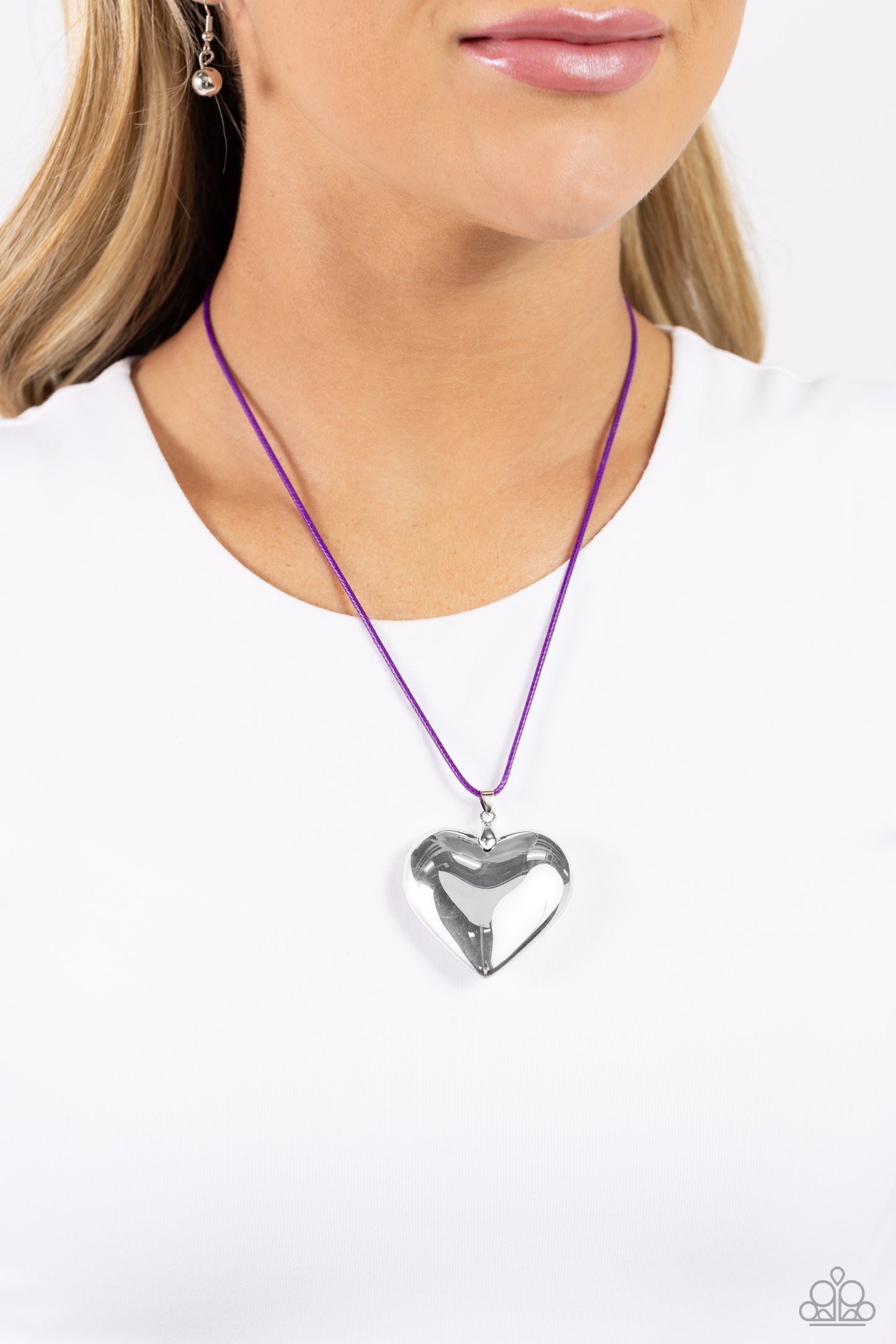 Paparazzi Accessories Devoted Daze - Purple An oversized, sleek silver heart glides along a vibrant purple cord, creating a flirtatious pendant below the collar. Features an adjustable clasp closure. Sold as one individual necklace. Includes one pair of m