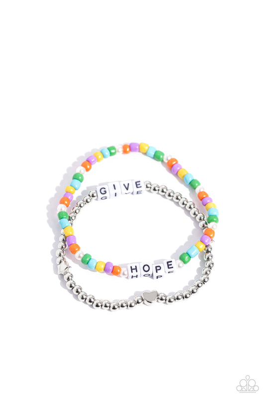 Paparazzi Accessories Giving Hope - Multi Threaded along stretchy bands around the wrist, a strand of silver beads with a silver heart bead combines with a multicolored strand of seed beads and glossy white pearls to create a stunning pop of color. White