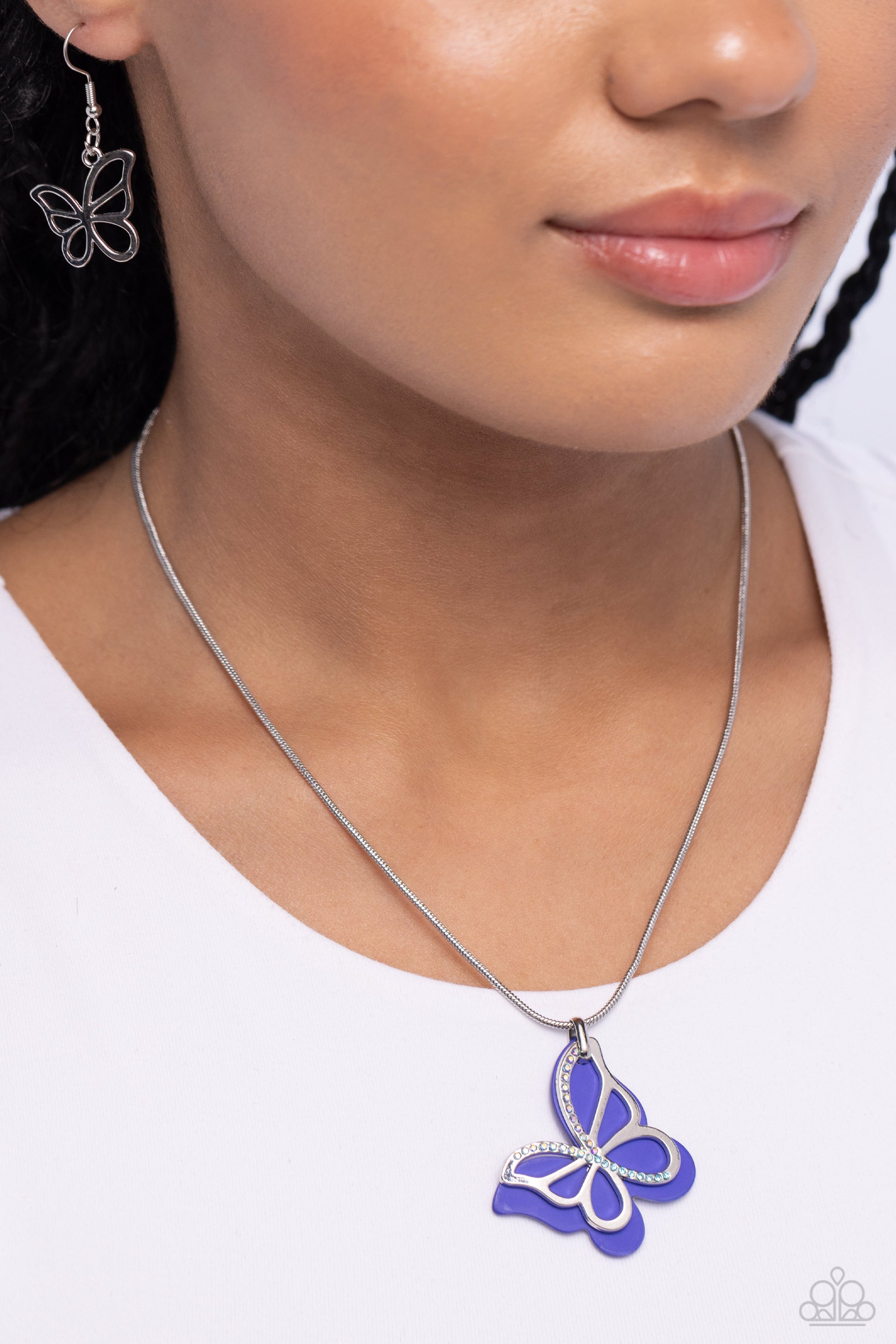 Paparazzi Accessories Detailed Dance - Blue Layered beside a silver butterfly silhouette dotted with aquamarine and blue-iridescent rhinestones, a royal blue-painted acrylic butterfly flutters from a silver snake chain below the collar for a whimsical fas