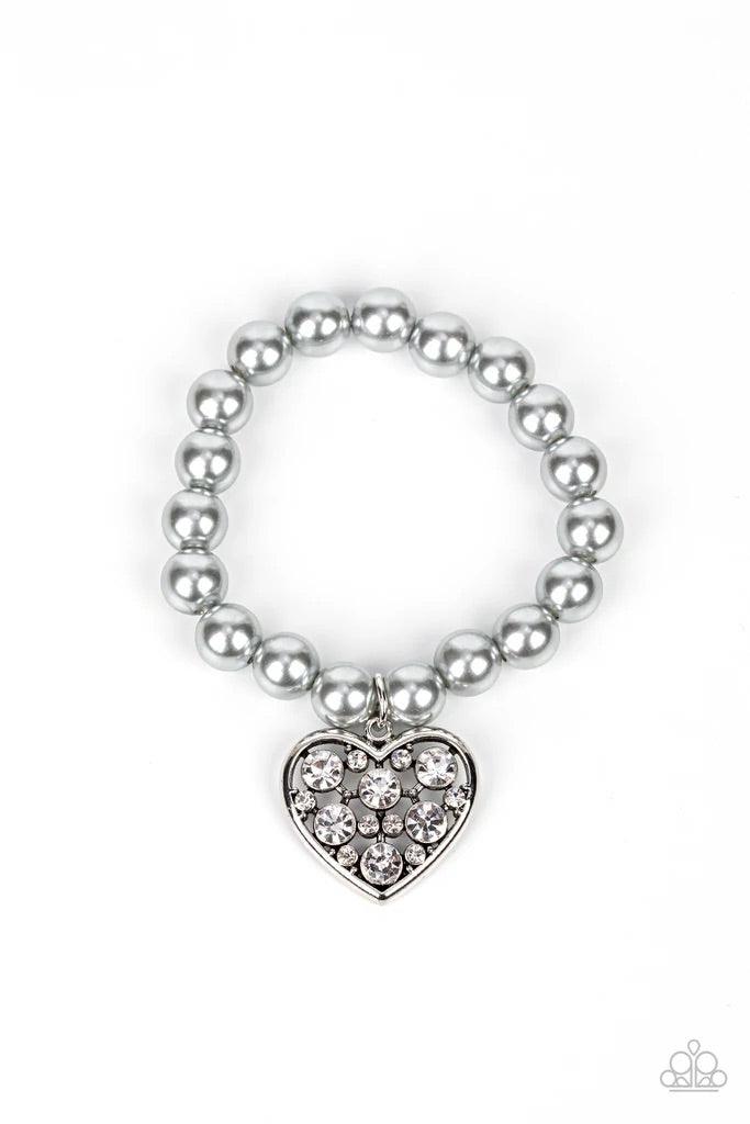 Paparazzi Accessories Cutely Crushing - Silver A dramatically oversized white rhinestone encrusted silver heart charm dangles from a stretchy strand of bubbly silver pearls, creating a flirtatious dazzle. Sold as one individual bracelet. Jewelry