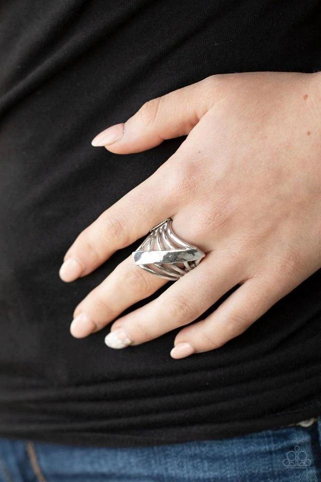 Paparazzi Accessories Encrypted Edge - Silver A daring hammered silver column slants across the finger intersecting an airy layered band resulting in a dramatically edgy vibe. Features a stretchy band for a flexible fit. Rings