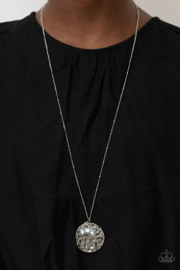 Paparazzi Accessories Seaside Shimmer - Blue A shimmering wavy silver disc sways from the bottom of a lengthened silver satellite chain. A cluster of Cerulean pearl beads dangles charmingly in front of the disc creating a tranquilly mystical pendant. Feat