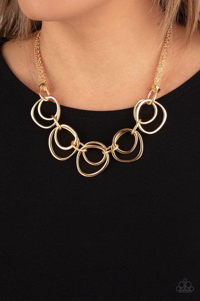 Paparazzi Accessories Asymmetrical Adornment - Gold Infused with decorative gold links, an asymmetrical assortment of gold rings delicately link below the collar for a refined flair. Features an adjustable clasp closure. Sold as one individual necklace. I