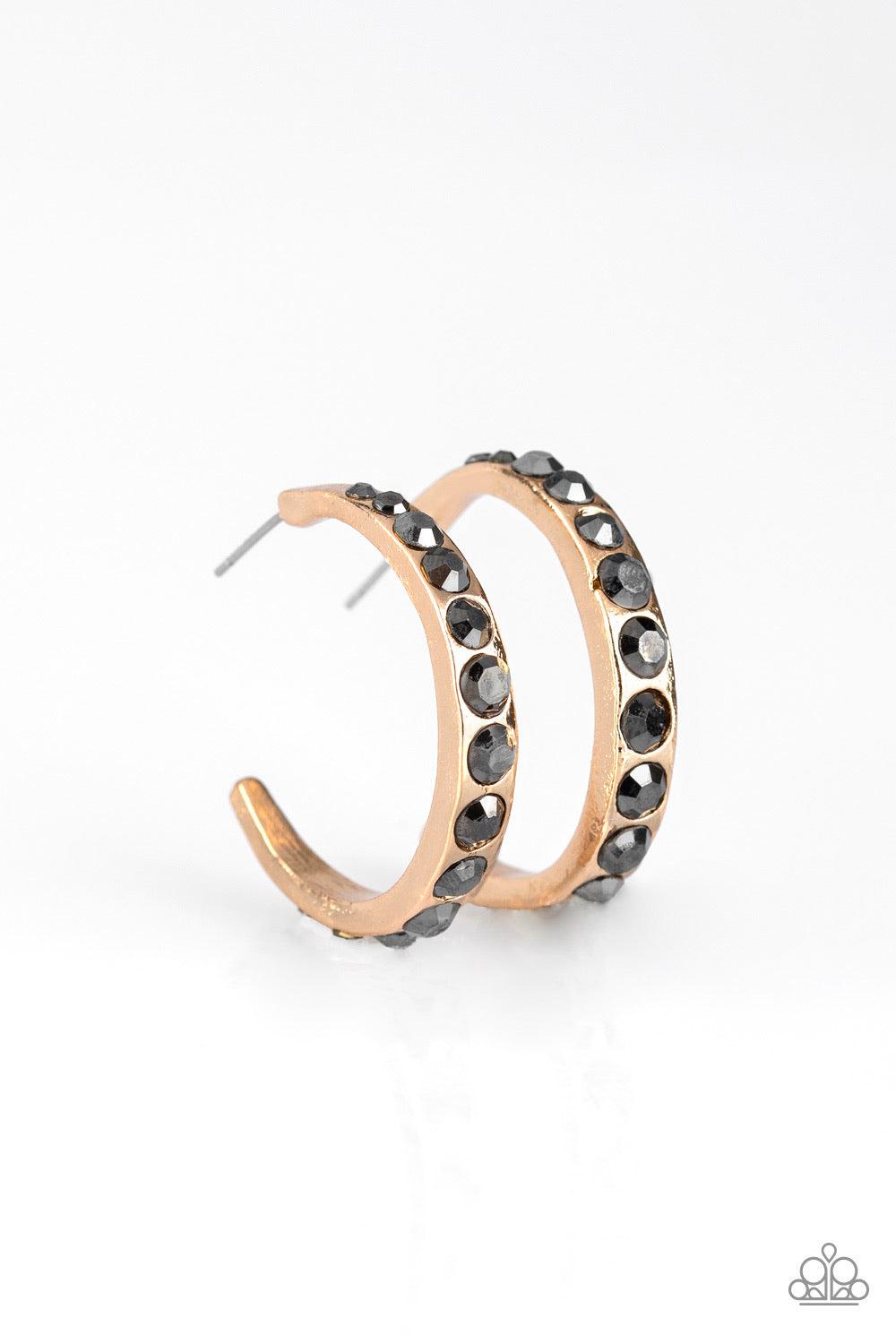 Paparazzi Accessories Welcome To Glam Town ~Gold Gradually increasing in size near the center, glassy hematite rhinestones are encrusted down the spine of a dainty gold hoop for a grunge-glamorous look. Earring attaches to a standard post fitting. Hoop me