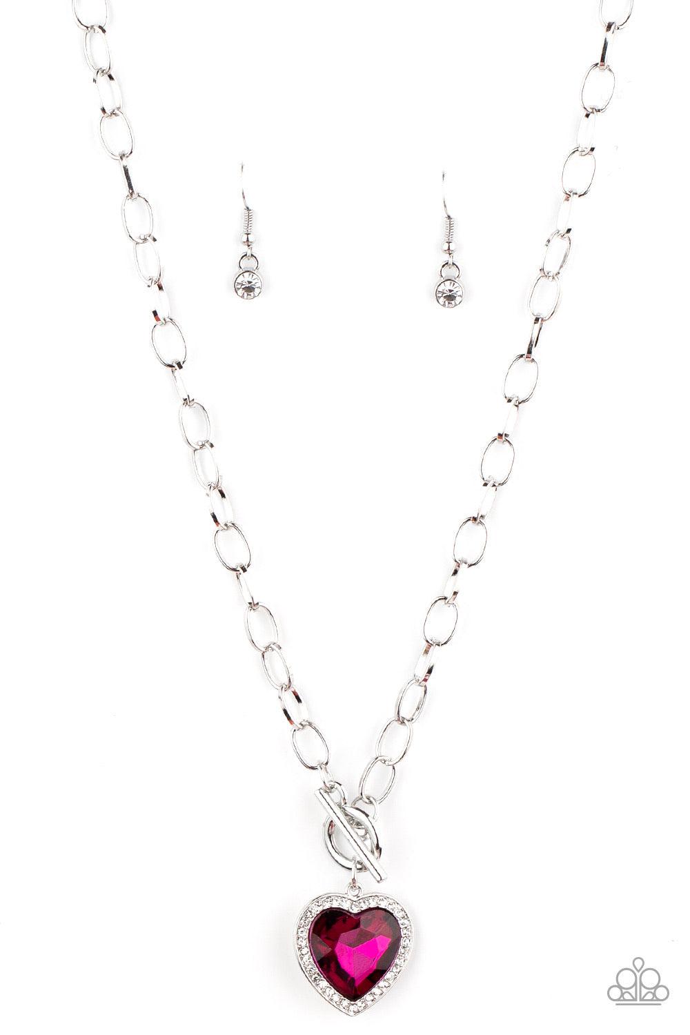 Paparazzi Accessories Check Your Heart Rate - Pink Bordered in glassy white rhinestones, a heart-shaped Pink Peacock gem is pressed into a shiny silver pendant at the bottom of a bold silver chain below the collar for a flirtatious finish. Features a togg