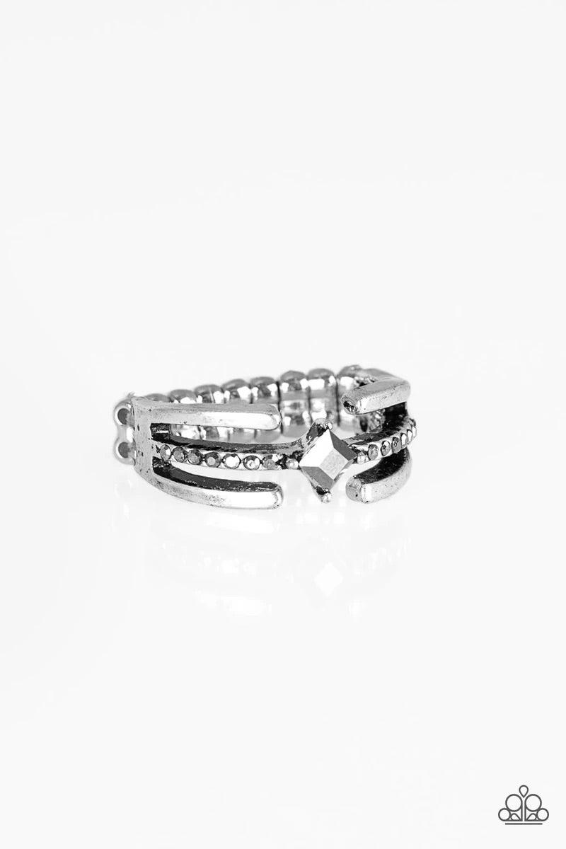 Paparazzi Accessories City Center - Silver Glistening silver bars gather around a sparkling hematite rhinestone encrusted band. Featuring a regal square cut, a hematite rhinestone is pressed into the center for an edgy finish. Features a dainty stretchy b