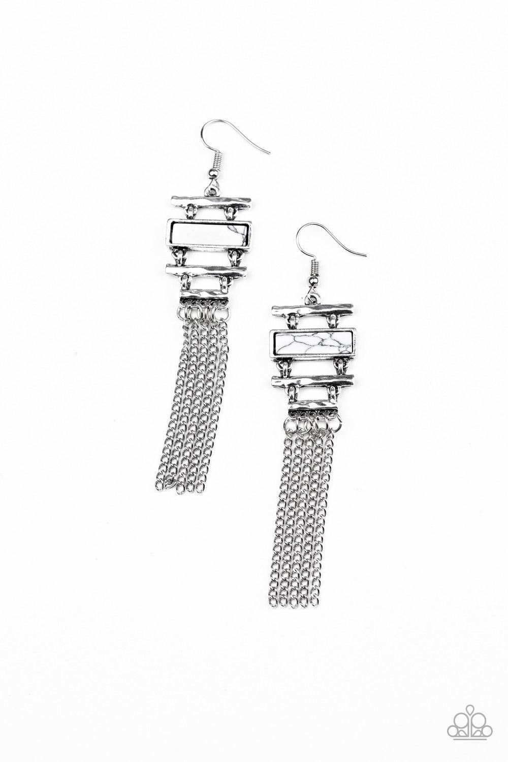 Paparazzi Accessories Stone Dwellings - White Infused with a flat white stone frame, hammered silver bars stack into an abstract lure. Shimmery silver chains stream from the bottom, creating a whimsical fringe. Earring attaches to a standard fishhook fitt