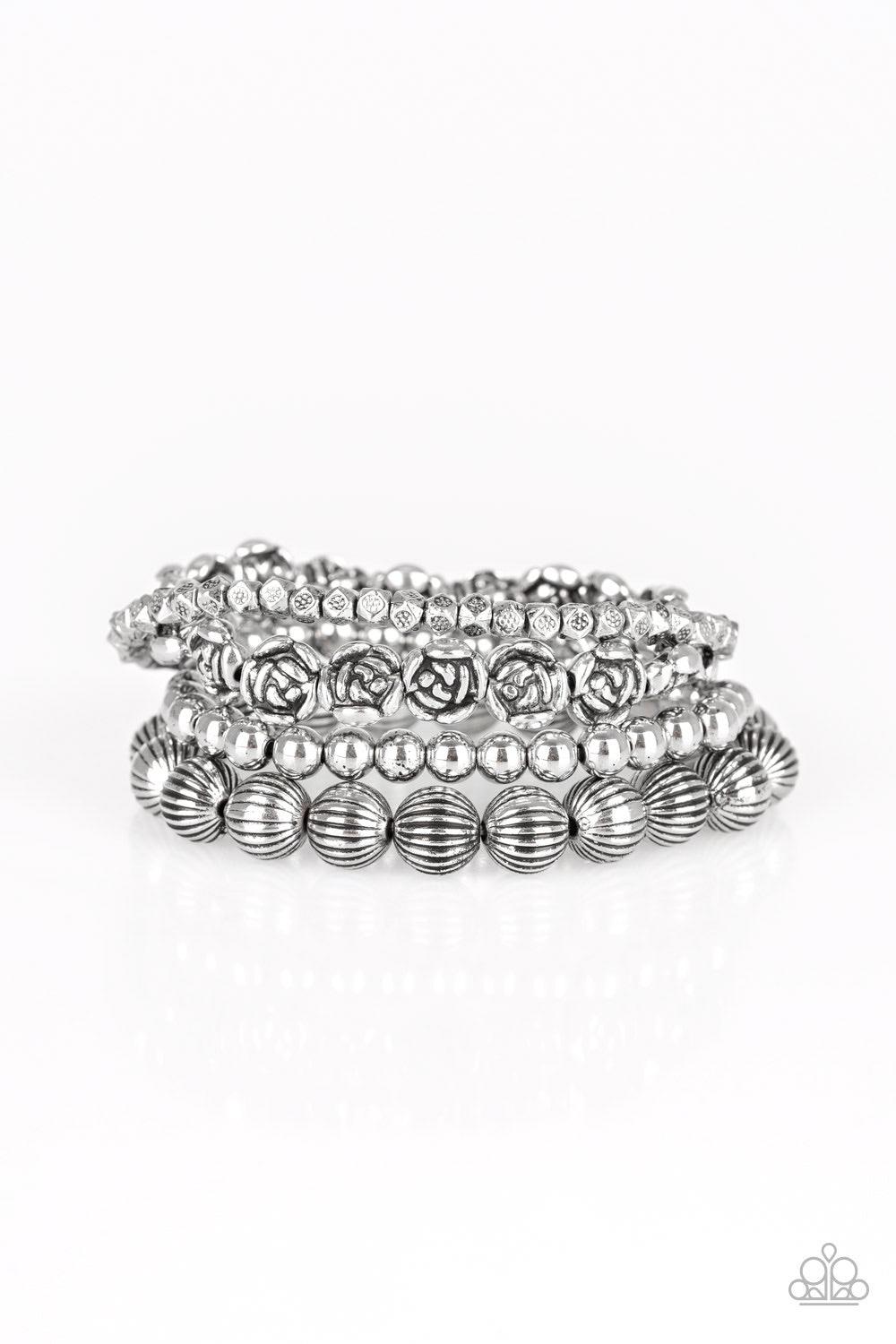 Paparazzi Accessories Rose Garden Gala -Silver A collection of silver roses, ornate silver beads, and dainty silver accents are threaded along stretchy bands, creating whimsical layers around the wrist.