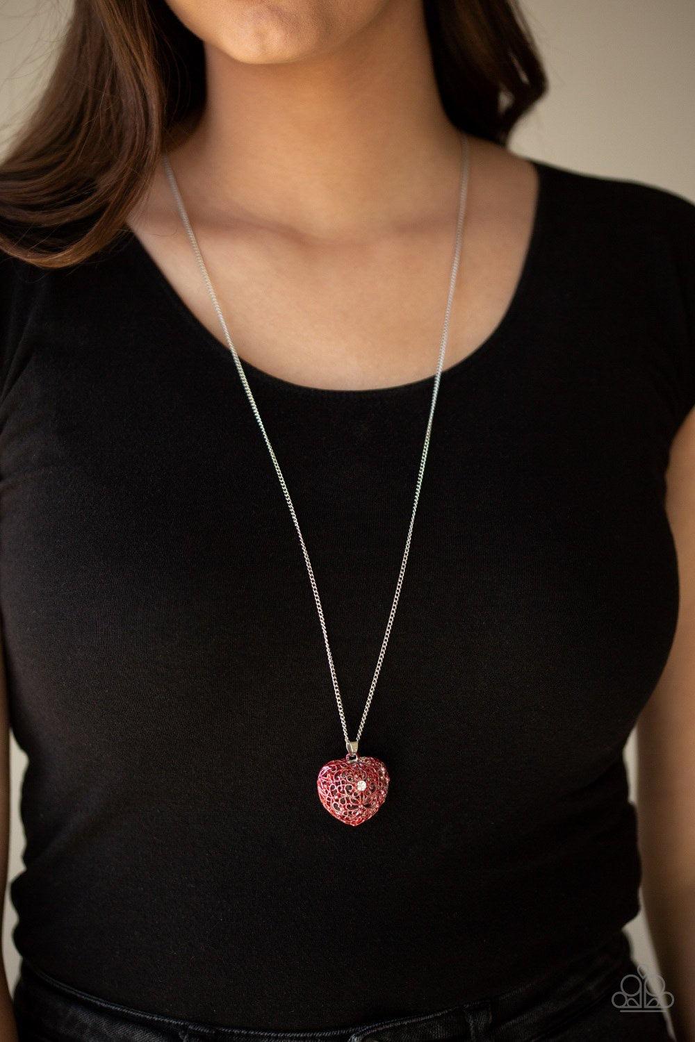 Paparazzi Accessories Love is All Around - Red Brushed in a shiny red finish, flowery filigree coalesces into a locket-like pendant at the bottom of a shimmery silver chain. A glassy white rhinestone dots the vintage inspired frame for a whimsical finish.