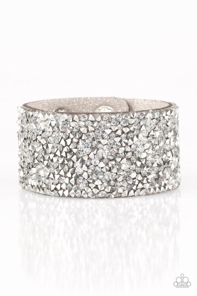 Paparazzi Accessories More Bang For Your Buck - Silver Featuring edgy prism style cuts, flashy metallic and glassy white rhinestones are sprinkled along a sparkling gray suede band, creating blinding shimmer. Features an adjustable snap closure. Sold as o
