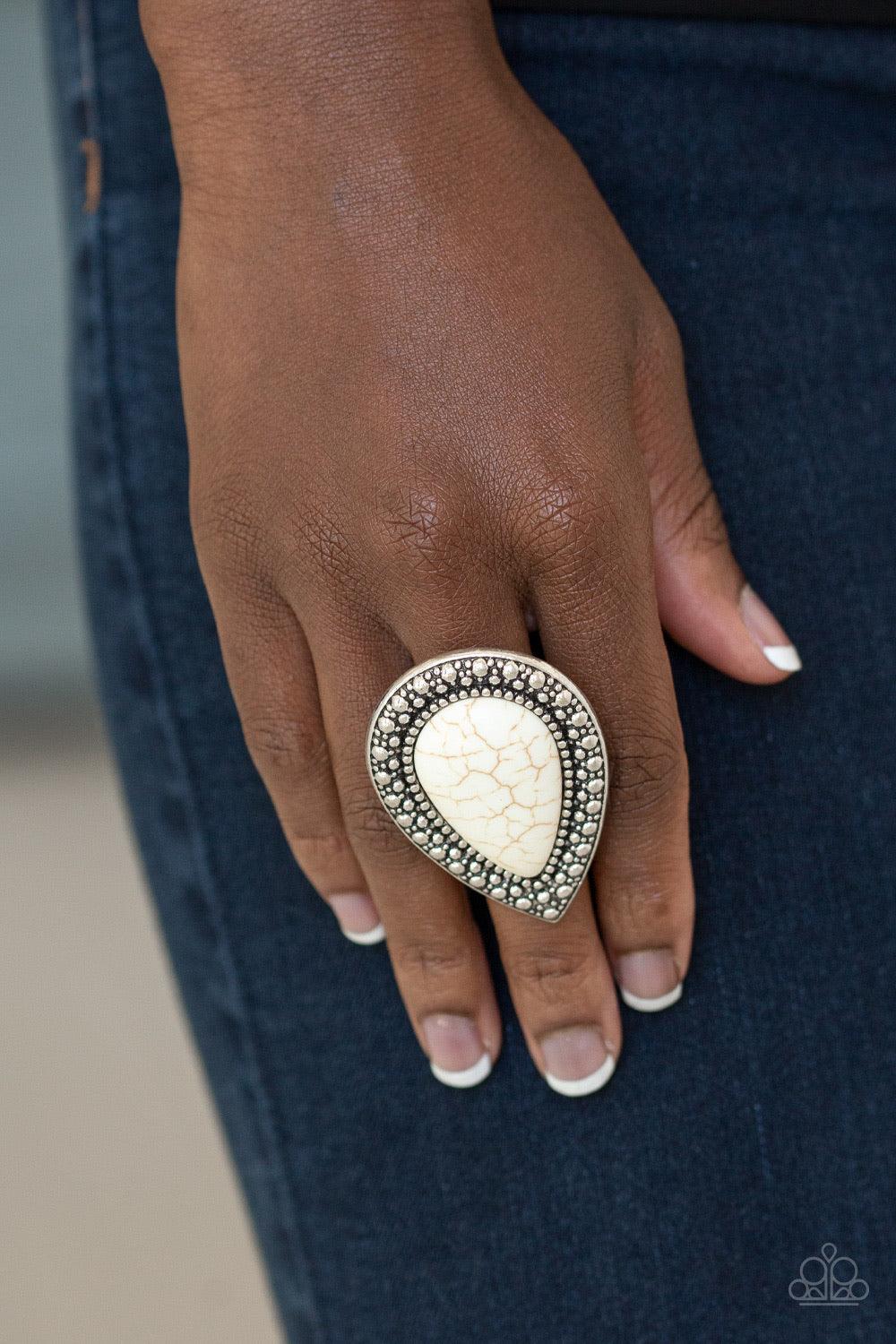 Paparazzi Accessories Santa Fe Storm - White Chiseled into a tranquil teardrop, an oversized white stone is pressed into the center of a shimmery silver frame dotted with radiant studded texture for a dramatic stone look. Features a stretchy band for a fl