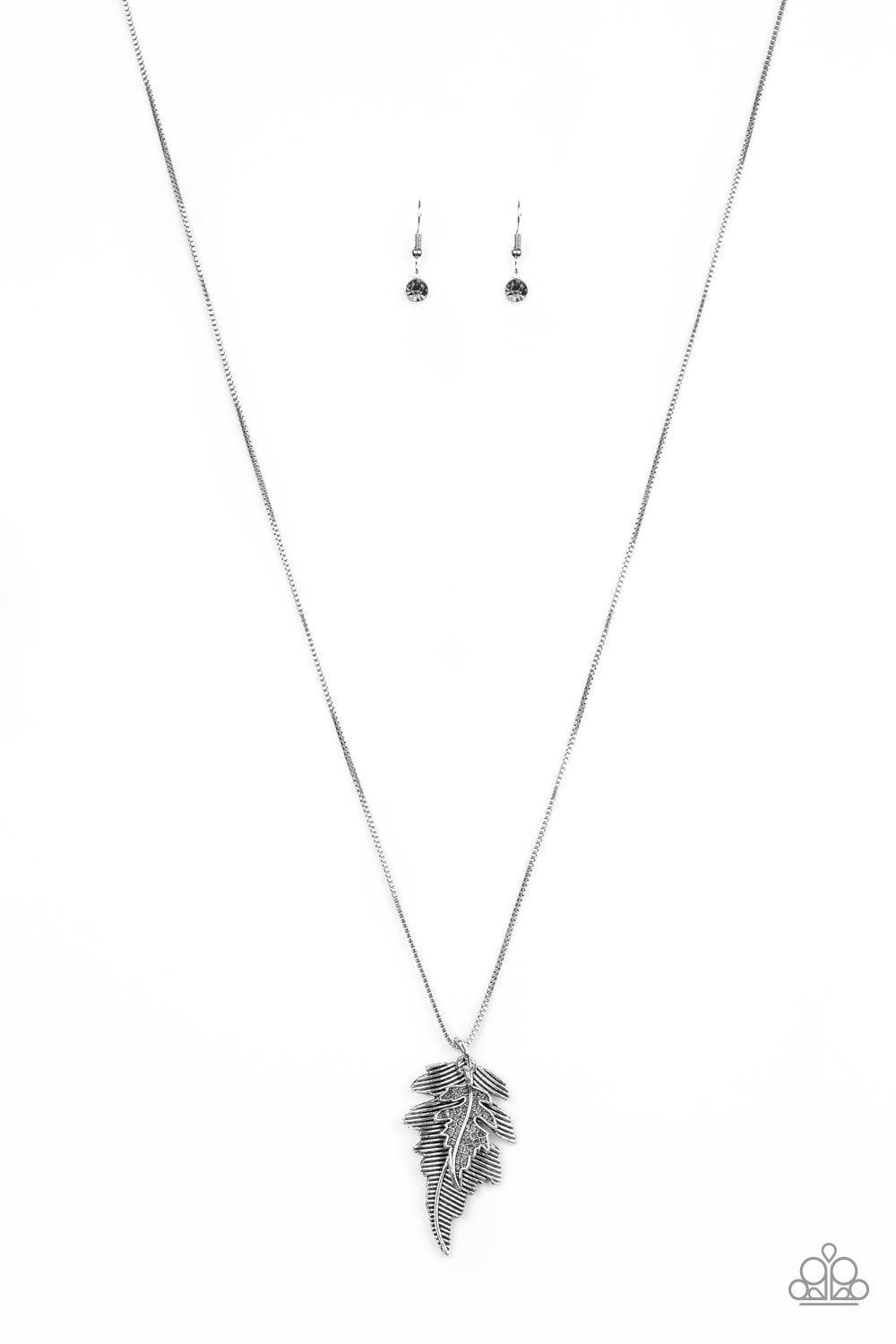 Paparazzi Accessories Enchanted Meadow - Silver Encrusted in smoky rhinestones and stacked with linear textures, feathery silver leaf pendants swing from the bottom of a lengthened silver chain for a seasonal flair. Features an adjustable clasp closure. J