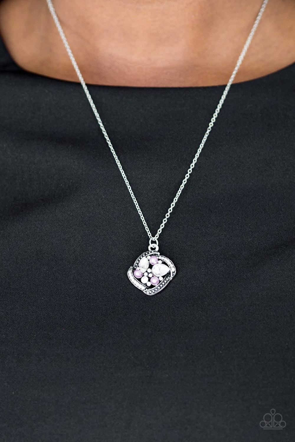 Paparazzi Accessories Speaking of Timeless - Purple Alternating in silver studs and glassy white rhinestones, dainty silver bars fold around a sparkling mishmash of glassy white rhinestones and dainty purple pearls. The sparkling pendant swings below the