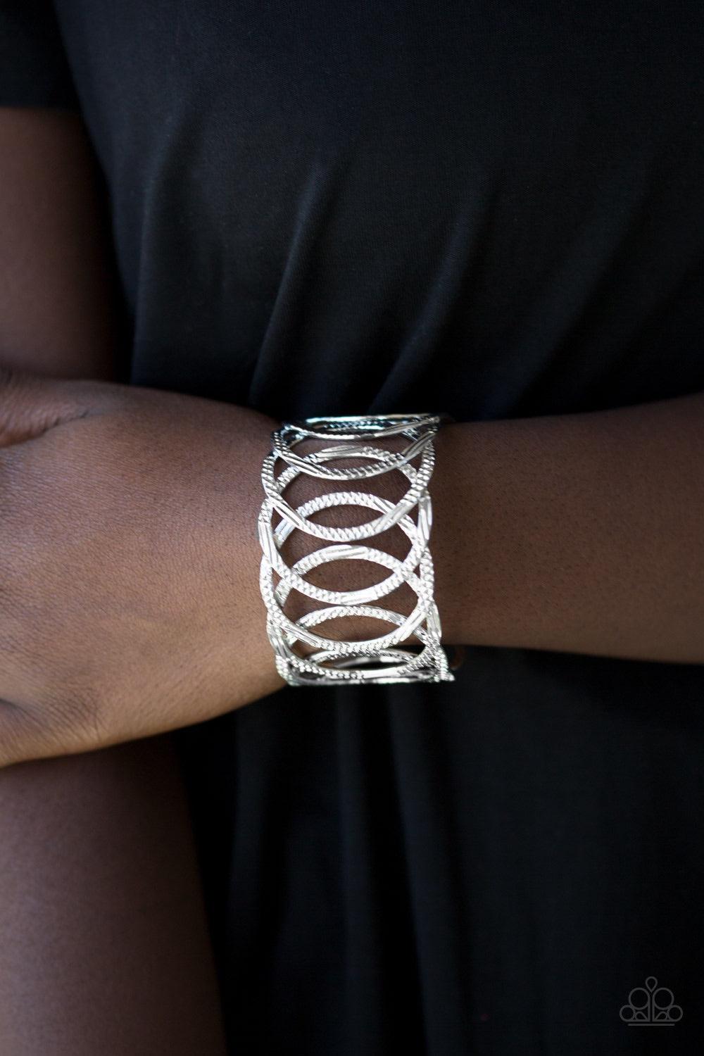 Paparazzi Accessories Circa De Contender - Silver Etched and hammered in linear and diamond-cut shimmer, glistening silver circles join into a dramatic cuff around the wrist. Jewelry
