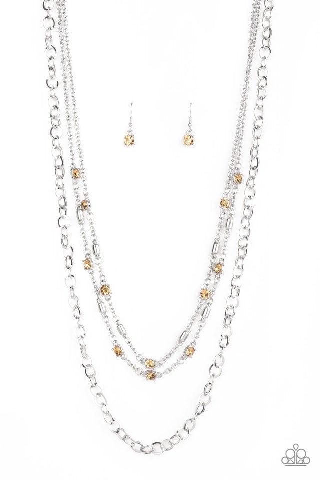 Paparazzi Accessories Metro Mixer - Brown Dotted with golden topaz rhinestones and glistening silver accents, a collision of mismatched silver chains layer down the chest for a refined flair. Features an adjustable clasp closure. Jewelry