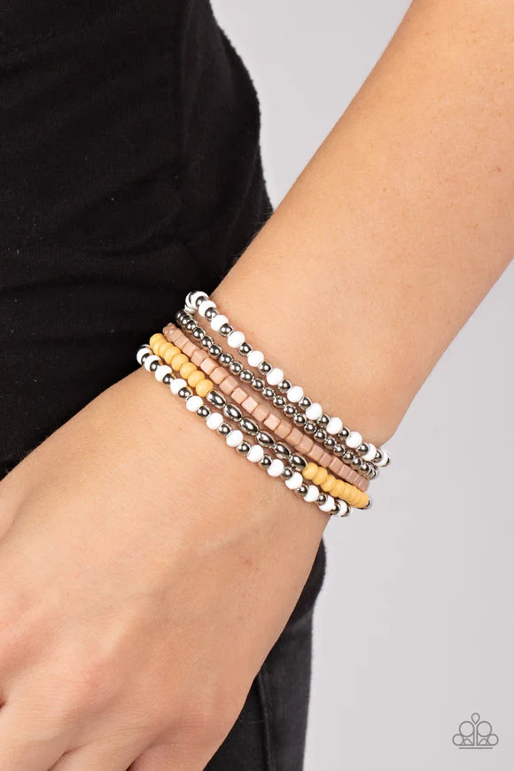 Paparazzi Accessories Adventure is Calling - Silver Featuring the neutral shades of white, brown, silver, and Daffodil, an adventurous assortment of round and cube beads are threaded along stretchy bands around the wrist for a colorfully layered Jewelry