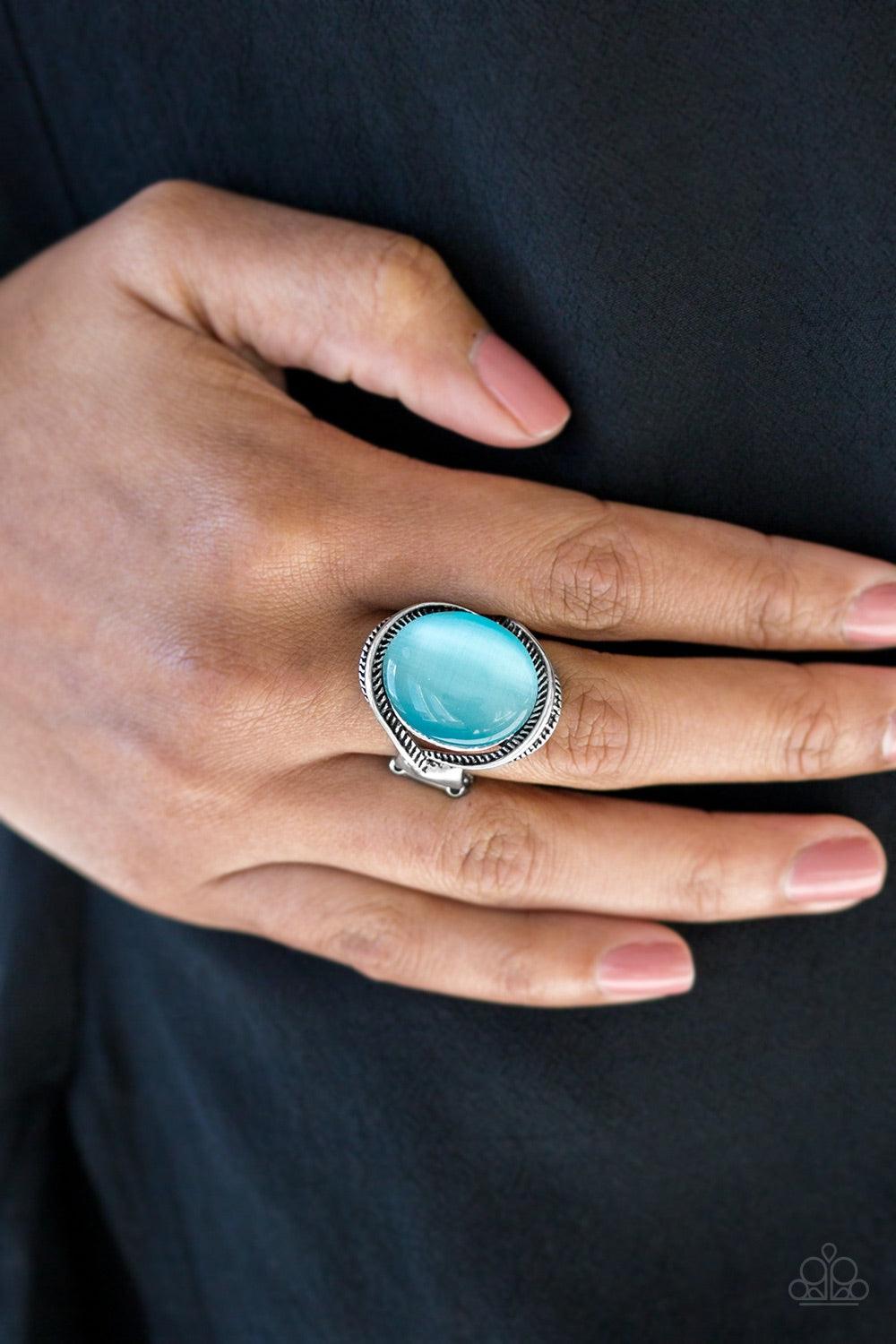 Paparazzi Accessories GLOW But Sure - Blue Etched in serrated textures, silver ribbons swoop around a glowing blue moonstone for a whimsical look. Features a stretchy band for a flexible fit. Jewelry