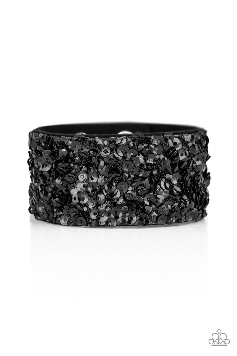 Paparazzi Accessories Starry Sequins - Black A collision of glittery black rhinestones and sparkling black sequins are encrusted along the front of a black suede band, creating blinding shimmer around the wrist. Features an adjustable snap closure. Jewelr