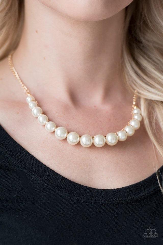 Paparazzi Accessories The FASHION Show Must Go On! - Gold A classic strand of white pearls is threaded along an invisible string, creating a stationary pendant below the collar. Infused with shimmery gold accents, gold chain weaves atop the pearls for a r