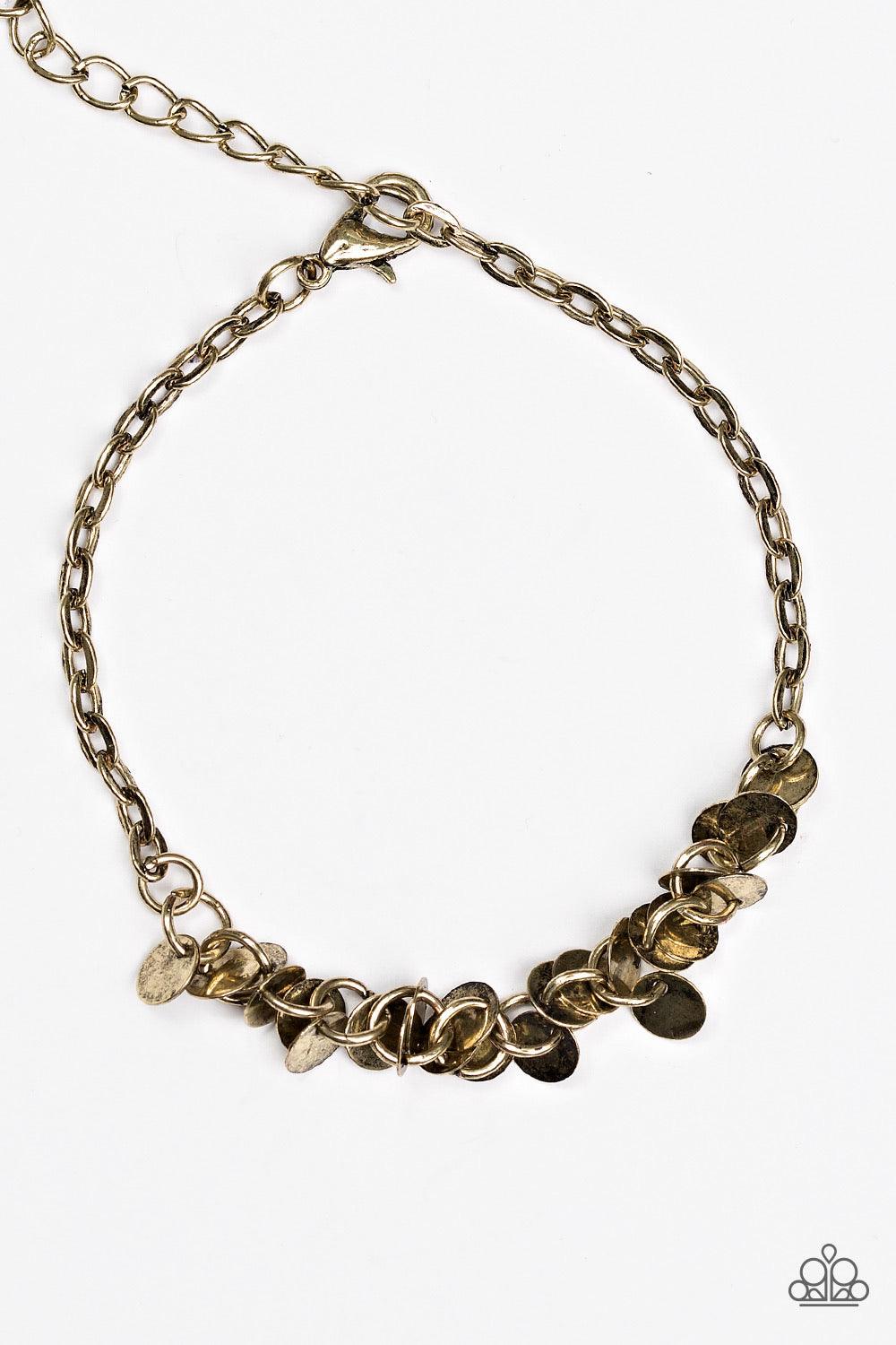 Paparazzi Accessories Shimmer Train - Brass Dainty brass discs trickle along the wrist, creating a flirty fringe. The flat shiny discs catch and reflect the light, creating playful movement across the skin. Features an adjustable clasp closure. Jewelry