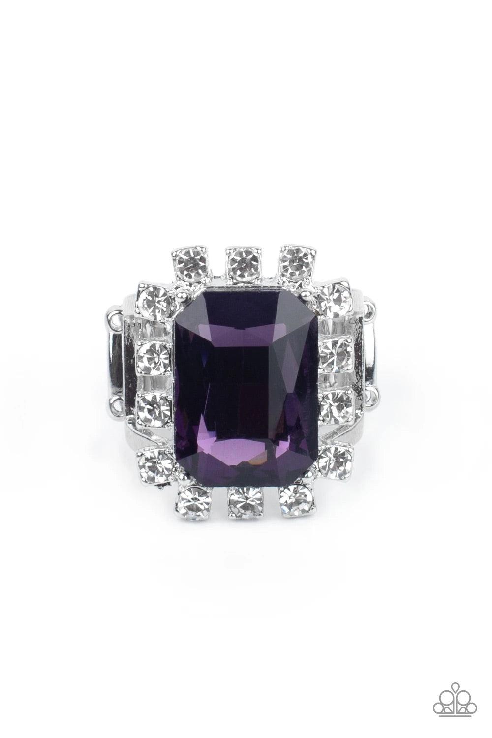 Paparazzi Accessories Galactic Glamour - Purple Featuring dainty silver square fittings, an explosion of glassy white rhinestones fans out from a dramatically oversized emerald cut purple rhinestone center, creating a stellar centerpiece atop the finger.