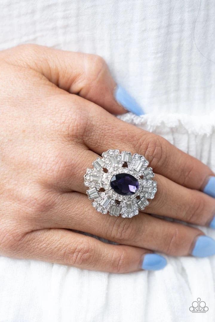 Paparazzi Accessories Iceberg Ahead ~Purple A sparkly series of round and emerald-cut rhinestone petals flare out from a purple oval rhinestone center, creating a dramatically oversized centerpiece atop the finger. Features a stretchy band for a flexible