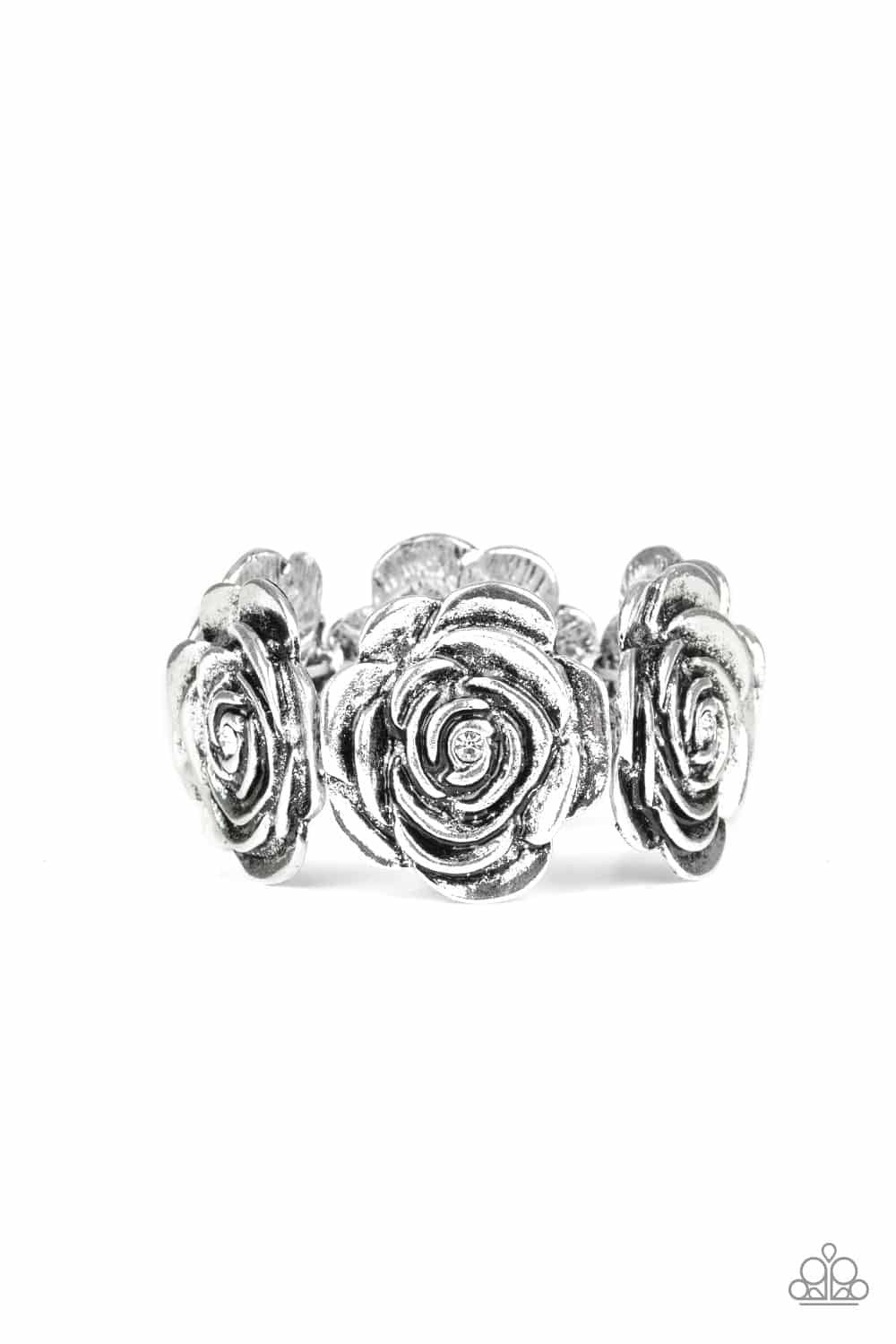 Paparazzi Accessories Floral Flamboyancy - White Dotted with dainty white rhinestone centers, a collection of oversized silver rosebud frames are threaded along stretchy bands around the wrist for a whimsical look. Jewelry