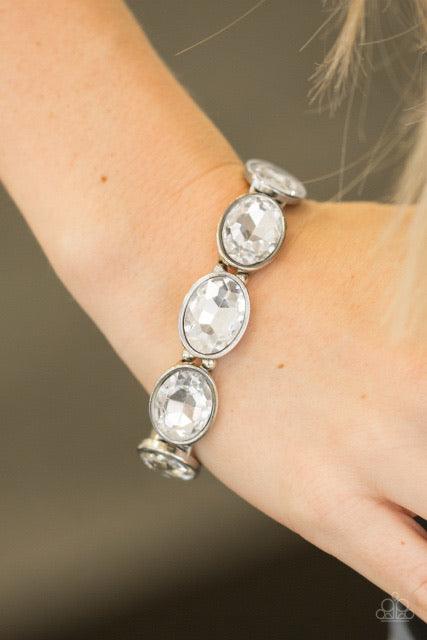 Paparazzi Accessories Diva In Disguise - White Glassy White gems are pressed into sleek silver frames. Infused with dainty silver beads, the glittery frames are threaded along stretchy elastic bands for a glamorous look around the wrist. Jewelry