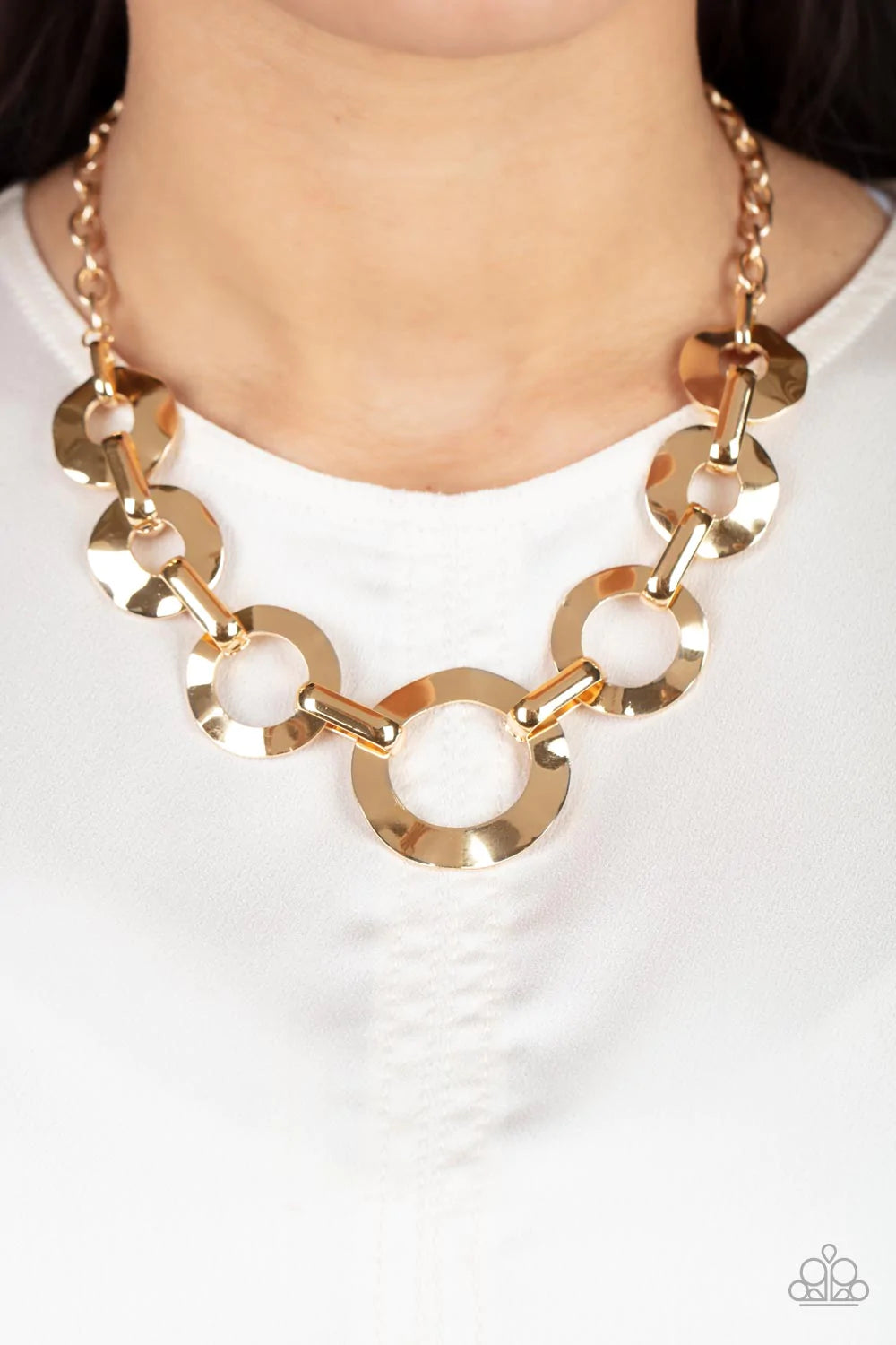 Paparazzi Accessories Mechanical Masterpiece - Gold Featuring hammered surfaces, crinkled gold rings gradually increase in size as they alternate with bold gold fittings below the collar for an intense industrial fashion. Features an adjustable clasp clos