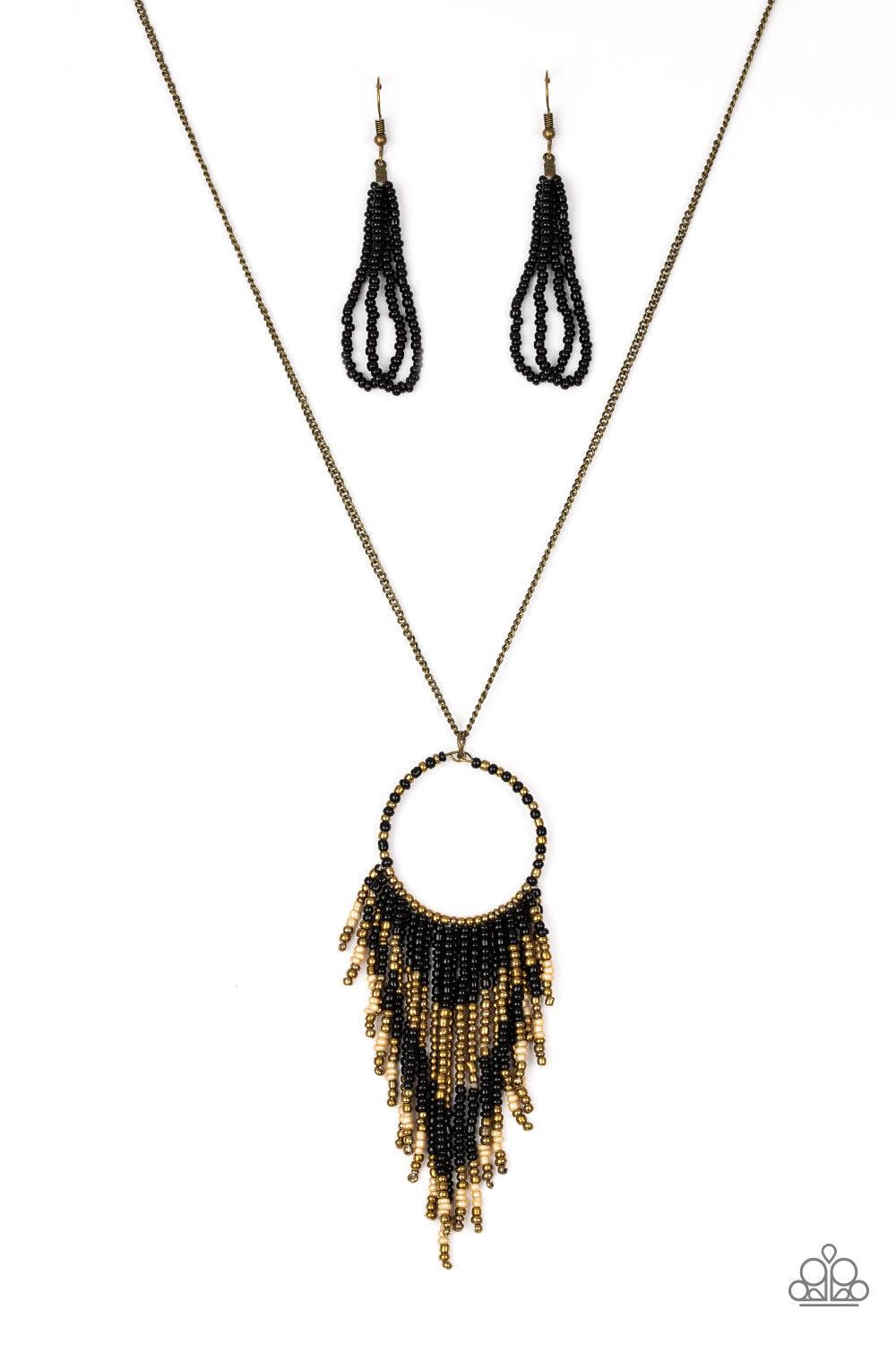 Paparazzi Accessories Badlands Beauty - Black Infused with black, brass, and brown seed beads, a colorful dream catcher like pendant swings from the bottom of a lengthened brass chain for a tribal inspired look. Features an adjustable clasp closure. Sold