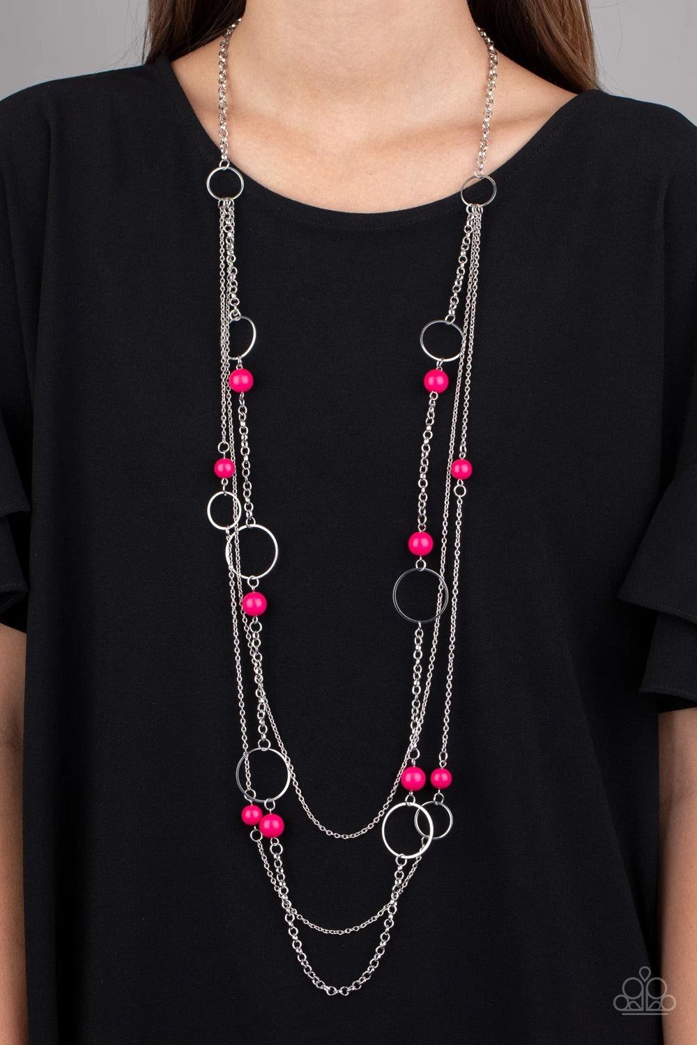Paparazzi Accessories Beachside Babe - Pink Featuring vivacious pink beads and shimmery silver hoops, mismatched silver chains layer down the chest for a seasonal look. Features an adjustable clasp closure. Sold as one individual necklace. Includes one pa