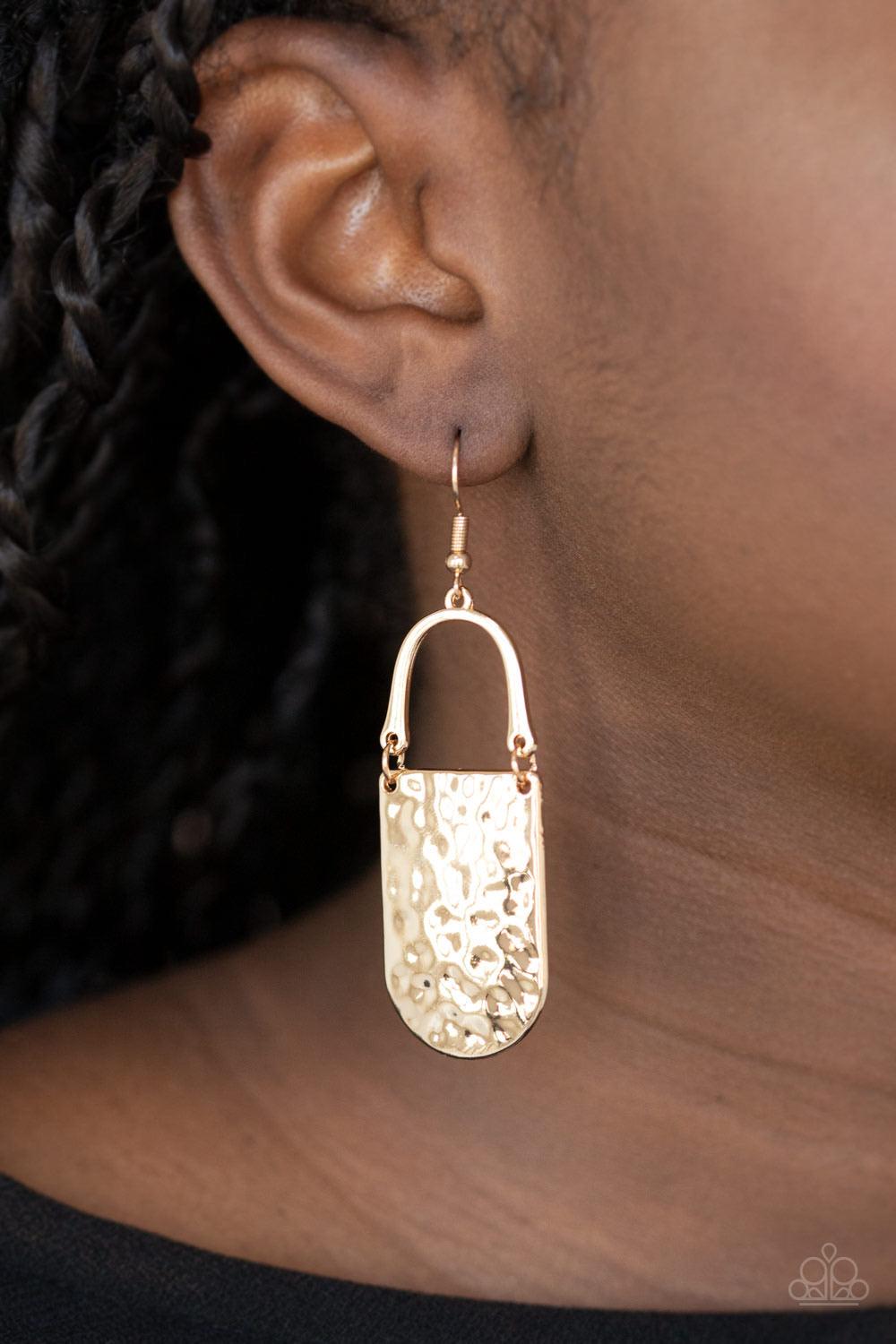 Paparazzi Accessories Resort Relic - Gold A hammered gold piece links to the bottom of a bowing gold bar, creating an abstract lure. Earring attaches to a standard fishhook fitting. Sold as one pair of earrings. Jewelry