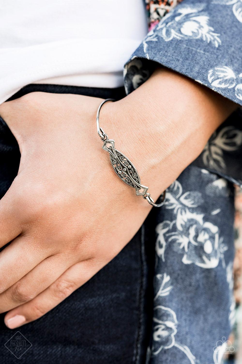 Paparazzi Accessories Exquisitely Empress - Silver An almond shaped frame is filled with vintage textures and nestled between two sleek silver bars for a minimalistic look. Jewelry