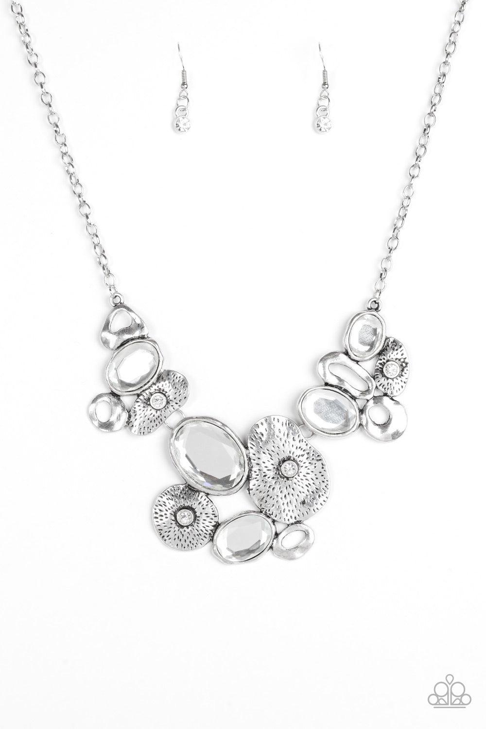 Paparazzi Accessories Grotto Grandeur - White Mismatched asymmetrical frames join below the collar. Sprinkled in dazzling white rhinestones, the delicately hammered silver frames connect with dramatic white gems for a glamorous finish. Features an adjusta