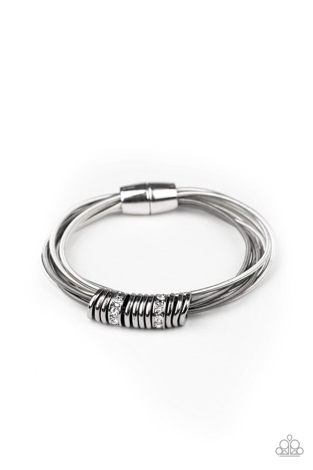 Paparazzi Accessories Magnetically Metro - Multi A collection of shiny gunmetal discs and white rhinestone encrusted rings slide along stretchy strands of spring-like gunmetal and silver bands for an edgy look. Features a magnetic closure. Sold as one ind
