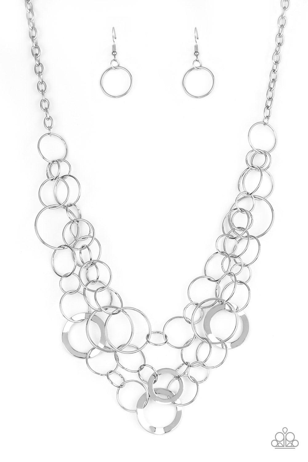 Paparazzi Accessories Main Street Mechanics - Silver Featuring beveled and smooth surfaces, mismatched silver rings link below the collar in three glistening layers for a gritty look. Features an adjustable clasp closure. Sold as one individual necklace.